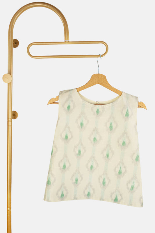 White sleeveless ikat silk top hanging on golden hanger